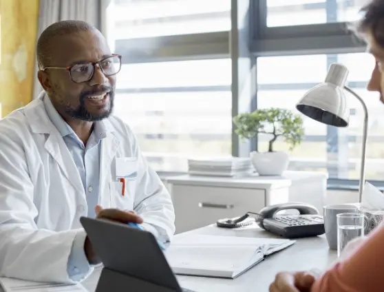 Male Doctor talking to patient while pointing at an ipad